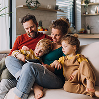 couple avec deux enfants, sur un canapé