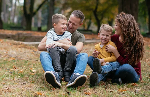 Visuels d'épargne retraite individuelle illustrant une famille heureuse assise sur de l'herbe  en fôret